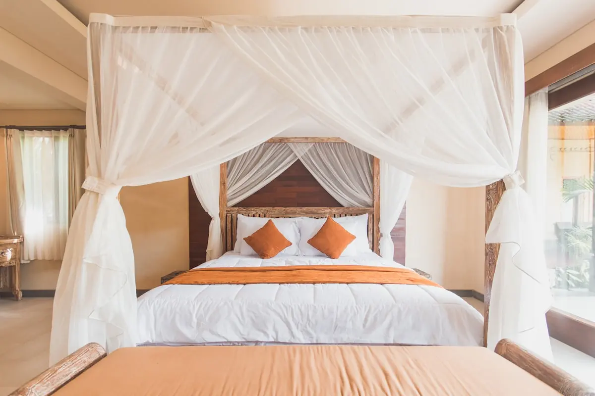 Kamar bergaya Bali dengan ranjang kayu berkelambu