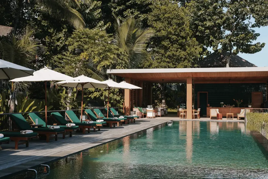 Kursi santai tepi kolam dan bar bale terbuka di Sanglung Villas & Suites